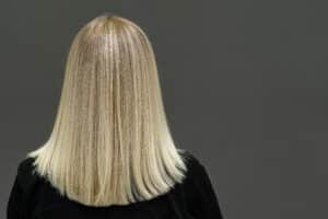 Blonde model with straight hair, look from behind. Hair lightening result.